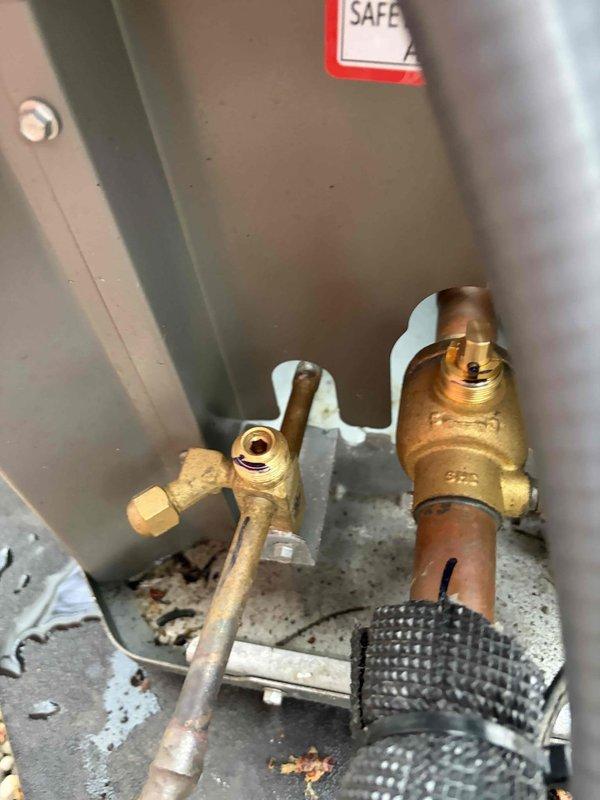 Completed system start-up and inspection on recently installed HVAC system with outdoor condensing unit and basement air handler. Verified proper operation of all equipment components, checked refrigerant connections and electrical disconnect, and confirmed unit placement on appropriate pad with proper clearances. Documented installation with photographs showing plumbing connections at air handler and exterior condenser positioning against building foundation.