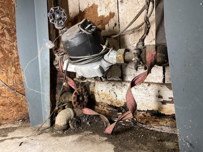 # Plumbing Estimate - Piping

Assessed first floor bathroom shower plumbing requiring PEX system installation with existing access panel availability. Upon inspection, discovered significant deterioration of existing mechanical systems in basement utility area, including heavily corroded pump/motor assembly with scattered damaged copper components, extensive rust staining, and water damage throughout the work zone. Documented existing conditions showing compromised ceiling joists with peeling paint, water-stained structural beams, and deteriorated mounting surfaces that will require remediation prior to new PEX installation. Photographed current plumbing infrastructure including exposed copper piping, valve assemblies, and connection points to develop comprehensive replacement scope. Identified water damage patterns suggesting long-term moisture intrusion affecting both mechanical equipment and surrounding structural elements. Evaluation complete for PEX piping system estimate to repla