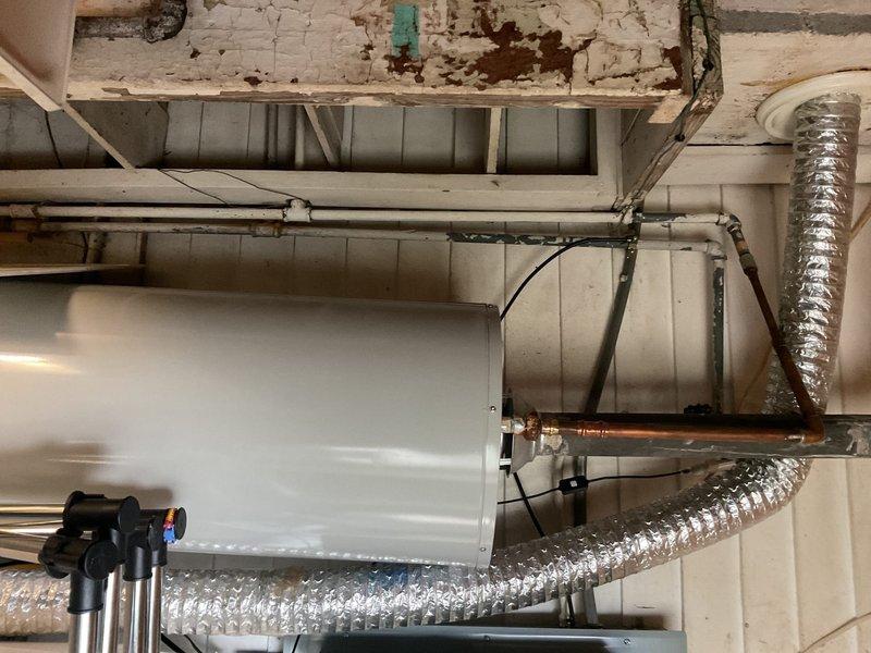 # Plumbing Estimate - Piping

Assessed first floor bathroom shower plumbing requiring PEX system installation with existing access panel availability. Upon inspection, discovered significant deterioration of existing mechanical systems in basement utility area, including heavily corroded pump/motor assembly with scattered damaged copper components, extensive rust staining, and water damage throughout the work zone. Documented existing conditions showing compromised ceiling joists with peeling paint, water-stained structural beams, and deteriorated mounting surfaces that will require remediation prior to new PEX installation. Photographed current plumbing infrastructure including exposed copper piping, valve assemblies, and connection points to develop comprehensive replacement scope. Identified water damage patterns suggesting long-term moisture intrusion affecting both mechanical equipment and surrounding structural elements. Evaluation complete for PEX piping system estimate to repla