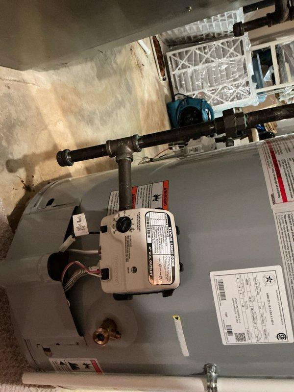 # Water Heater Service Call

Responded to no hot water complaint on six-year-old residential gas water heater in basement storage room. Upon arrival, performed diagnostic inspection of unit originally installed by Flame. Examined water heater tank, gas valve control assembly, supply and discharge piping, and pressure relief valve. Checked digital temperature controller display for proper operation and settings. Inspected all plumbing connections at top of tank including hot and cold water lines. Evaluated gas line connections and control valve functionality. Assessed overall unit condition and verified all safety labels and manufacturer specifications were intact. Documented equipment status with photographic evidence showing complete installation setup and control panel readings. Unit evaluated for potential repair versus replacement options based on age and service history.