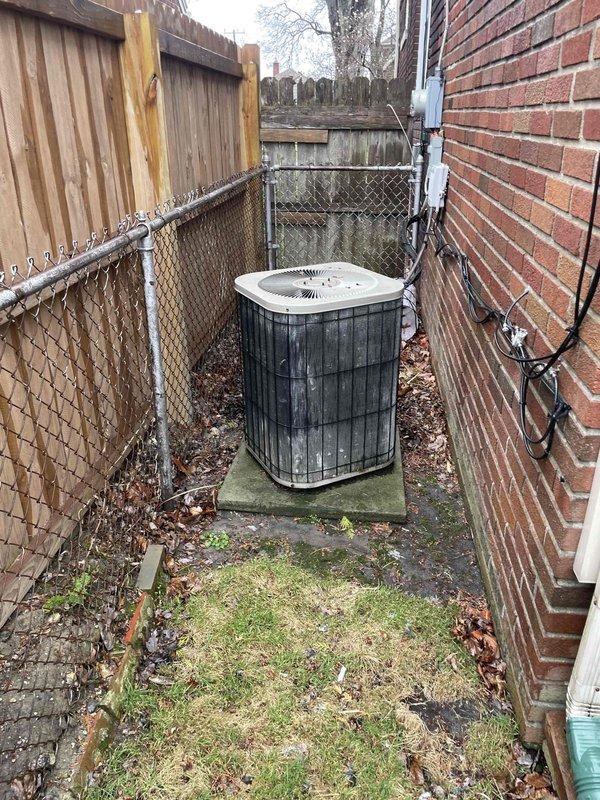 Conducted comprehensive site assessment for full HVAC system replacement at residential property. Evaluated existing gas furnace and outdoor condensing unit, both showing significant age and weathering. Documented current equipment configuration including exterior-mounted condenser unit on concrete pad in narrow side yard, electrical service connections via wall-mounted conduit and junction box, and utility access points. Photographed equipment placement, clearance constraints in confined side yard area between brick structure and chain-link fencing, and existing infrastructure for replacement planning. Assessed installation challenges including limited working space, proper clearances for new equipment, and electrical service requirements. Provided detailed estimate for complete system replacement including new high-efficiency gas furnace and matching outdoor condensing unit.
