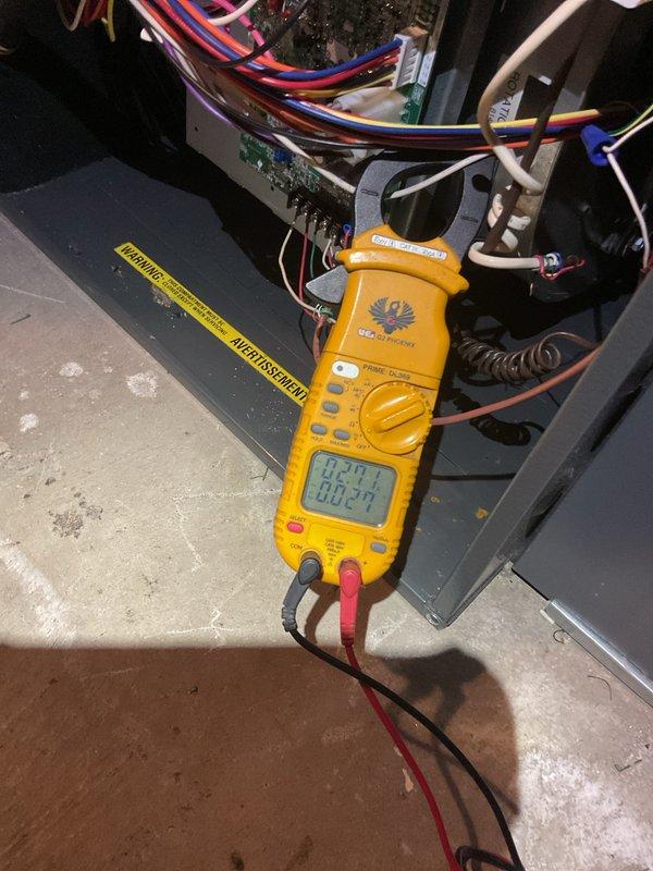 Completed comprehensive Gold AC inspection on 34-year-old residential air conditioning system with air handler located in basement and condensing unit positioned exterior against building. Performed electrical diagnostics using clamp meter, measuring voltage and amperage at control board to verify proper system operation, inspected all electrical connections, wiring, and components within air handler cabinet. Conducted thorough examination of outdoor condensing unit including fan motor operation, refrigerant pressures, and overall mechanical condition, noting unit's advanced age and continued functionality.