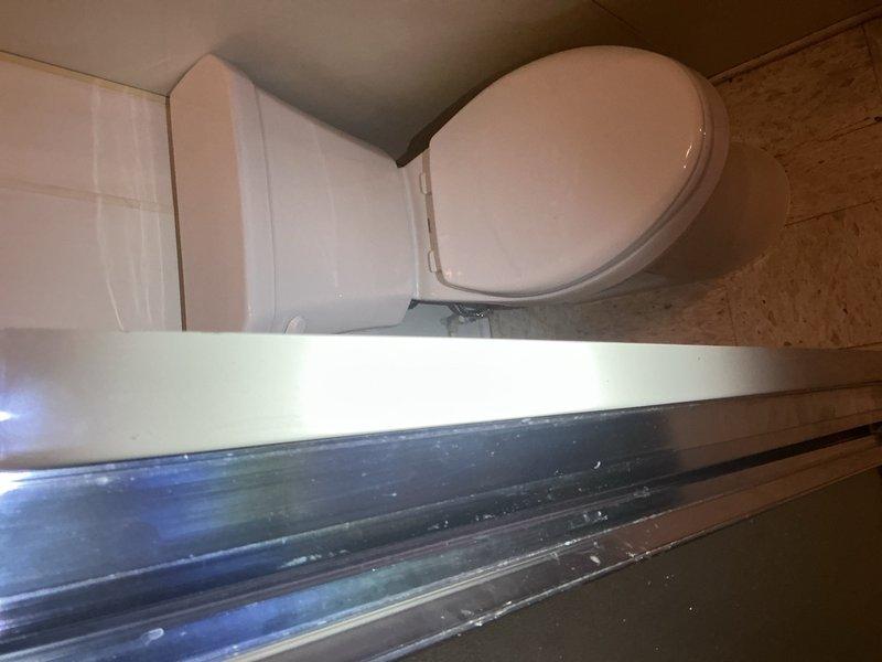 Completed toilet installation in residential bathroom per customer request with morning arrival window. Removed existing toilet fixture and installed new white porcelain toilet with standard oval seat design, ensuring proper sealing and secure mounting to floor flange. Verified proper water supply connection, tested flush mechanism for adequate water flow and drainage, and confirmed no leaks at base or supply line connections. Materials were sourced from Madison Heights plumbing supply under designated purchase order. Installation completed on existing wood-grain laminate flooring with all fixtures operating correctly upon completion.