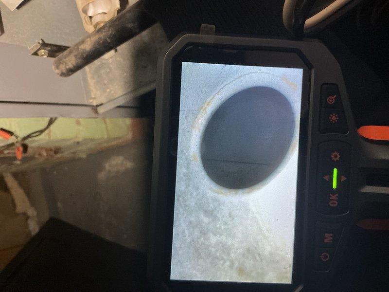 Completed comprehensive tune-up inspection on basement-located furnace unit. Performed visual inspection of all accessible components, utilized borescope camera to examine internal ductwork and heat exchanger passages for cracks, corrosion, or blockages. Documented existing cabinet damage with exposed metal edges and deterioration at top panel seam. All equipment operational at time of service, system running as designed with no immediate safety concerns identified.