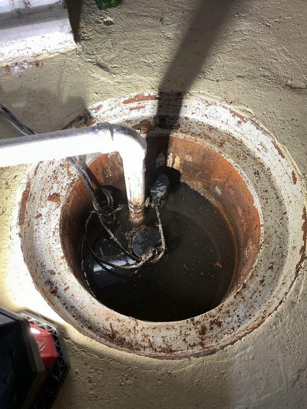 Responded to service request for sump pump evaluation and same-day installation following initial electrical assessment. Upon arrival, inspected existing sump pump system and found severe corrosion throughout the unit, including extensive rust damage to the pump housing, motor assembly, and discharge piping. The pump basin exhibited significant rust staining on interior walls with degraded protective coating. Water in the pit appeared dark and sediment-laden, indicating compromised pump performance.

Provided comprehensive estimate for complete sump pump replacement, including removal of failed corroded unit and installation of new pump system with appropriate discharge piping and electrical connections. Customer accepted estimate and authorized same-day installation. Removed deteriorated pump assembly and cleaned sump basin of accumulated sediment and debris. Installed new sump pump with check valve, ensuring proper float operation and discharge routing. Tested system operation throug