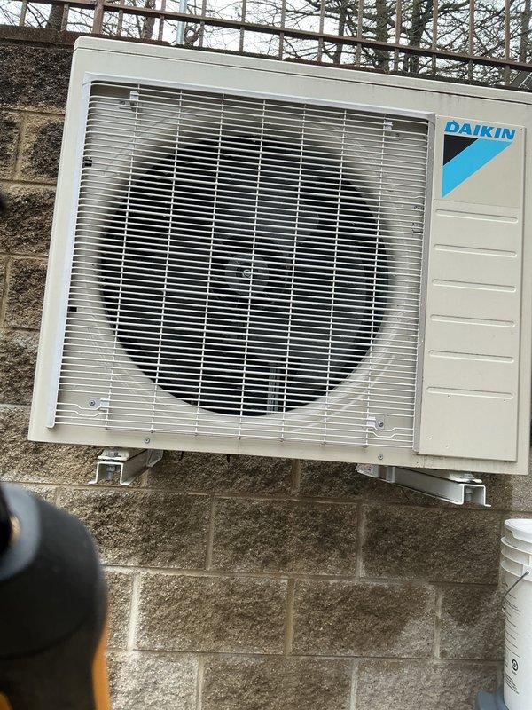 Completed comprehensive Gold AC inspection on residential property with multiple systems including a Daikin mini-split unit in garage and central AC system with air handler located in basement. Due to limited attic access, smaller technician performed inspection of less than 10-year-old equipment. Both outdoor condenser units were inspected and photographed, confirming proper mounting, adequate clearances from structures, and normal operational condition. All systems were functioning properly at time of inspection with no immediate repairs required.