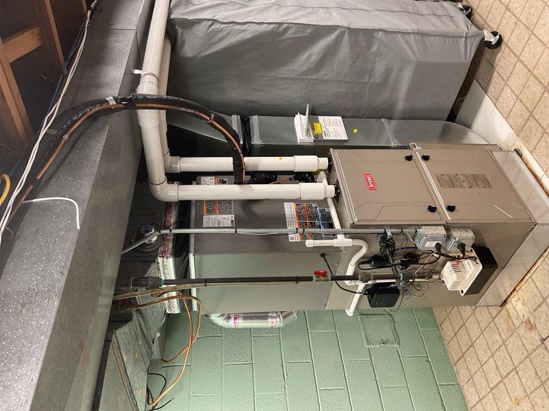 Completed installation of two 4-ton air conditioning systems with matching evaporator coils utilizing two installation crews. First outdoor condensing unit positioned on concrete pad in rear yard area adjacent to brick exterior wall with proper clearances maintained. Second system installed with indoor air handler and coil assembly in interior utility space with Maytag furnace integration. Refrigerant lines run with appropriate insulation, PVC condensate drainage piping installed and routed to proper termination points, electrical connections completed including disconnect boxes and proper wire sizing. All systems pressured tested for leaks, evacuated, and charged to manufacturer specifications. Units powered up, tested for proper operation including temperature split verification, airflow confirmation, and safety control functionality. Installation completed per code requirements with all reconnections finalized and systems operational.