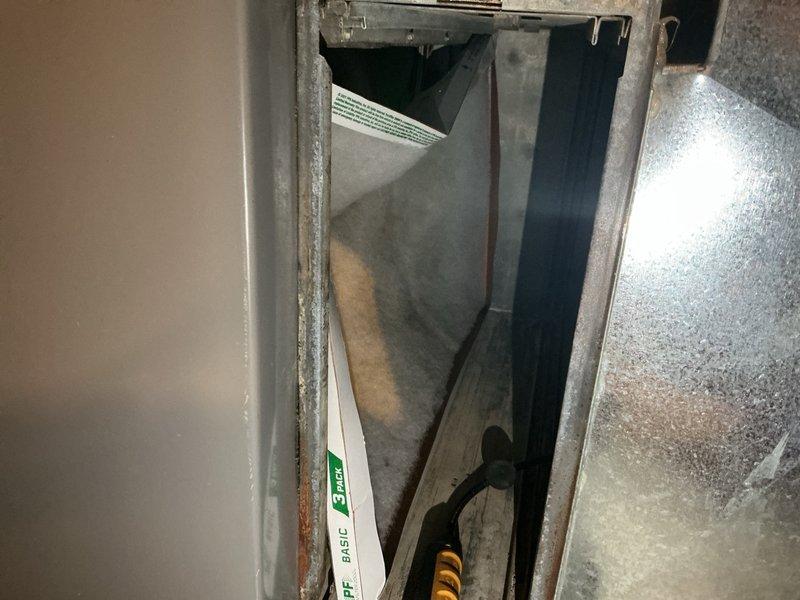 Responded to no-cooling complaint where outdoor condenser fan operated but no airflow from interior vents. Inspected outdoor unit and accessed indoor air handler through service panel. Diagnosed complete airflow restriction caused by severely clogged air filter preventing circulation through ductwork. Replaced dirty filter with new unit, restored proper airflow to all supply registers, and verified system cooling operation.