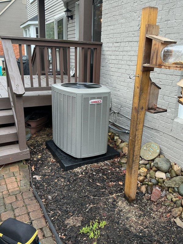 Completed air conditioning system startup on Lennox outdoor condenser unit. Performed comprehensive system commissioning including verification of refrigerant charge, electrical connections, and operational testing to ensure proper cooling performance. Documented installation with photographs showing exterior condenser placement on composite pad and interior condensate drain piping configuration connected to water heater system.