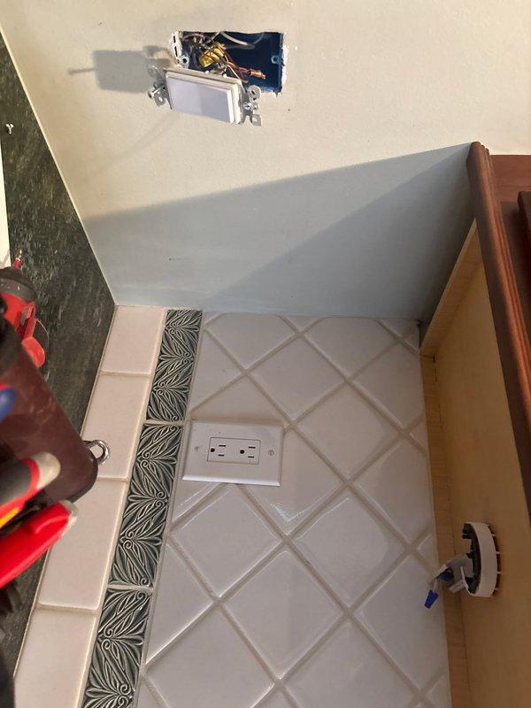 Responded to service call for non-functional under-cabinet and range hood lighting in kitchen area. Performed diagnostic assessment of electrical circuit serving decorative tile backsplash area with existing outlet installation. Troubleshot wiring connections at junction box location near ceiling where cabinet lighting fixtures tie in. Identified and resolved electrical connectivity issue affecting lighting operation. Verified proper function of cabinet lighting system and confirmed all electrical connections secure and code-compliant upon completion.