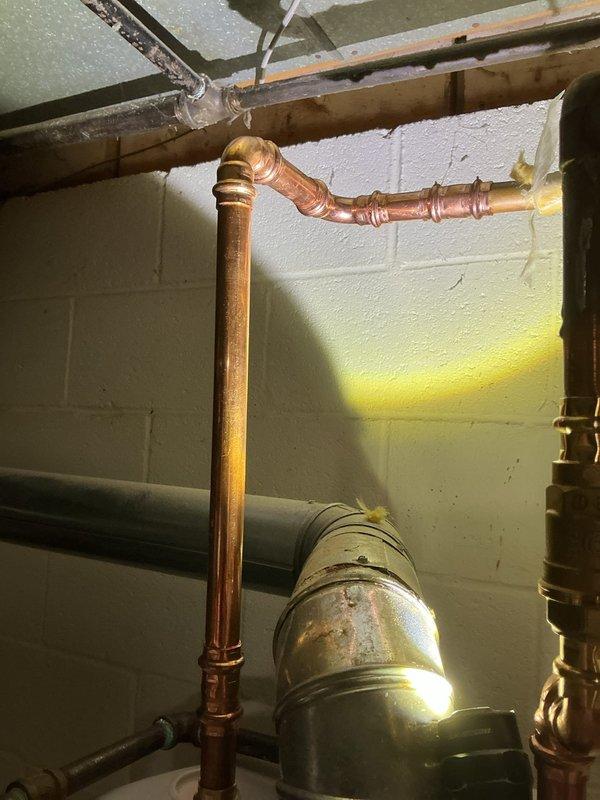 Replaced hot side copper riser that was previously omitted during water heater installation. Installed new copper piping with proper 90-degree elbow fittings along vertical run in basement utility area. Completed installation according to estimate specifications, ensuring proper connections and system integrity for residential hot water distribution system.