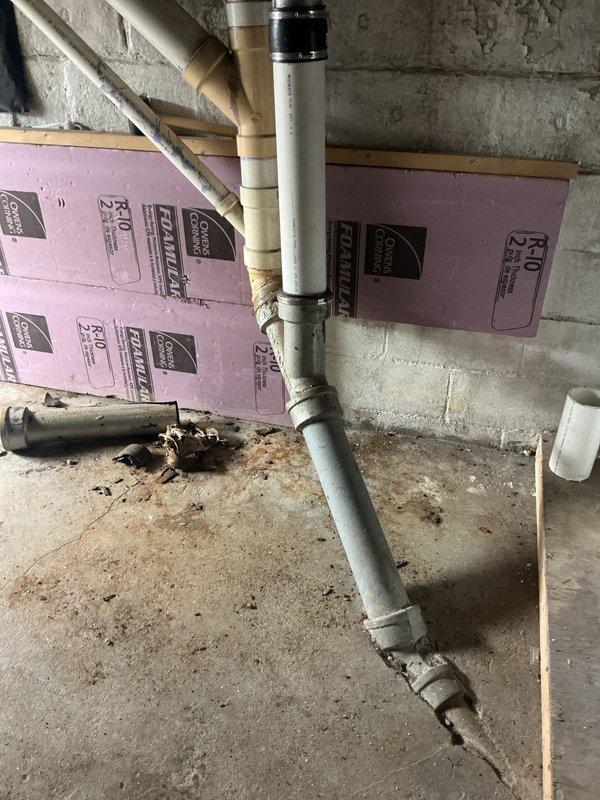 Responded to service call for leaking downstairs wastewater pipe in basement area. Upon inspection, identified compromised PVC drainage piping running along concrete block foundation wall. Assessed plumbing system configuration including vertical and horizontal drain lines with multiple joints and fittings. Evaluated pipe connections and determined source of water leak in wastewater drainage system. Completed necessary repairs to eliminate active leak and restore proper drainage function. Verified system integrity and confirmed no additional moisture intrusion following repair completion.