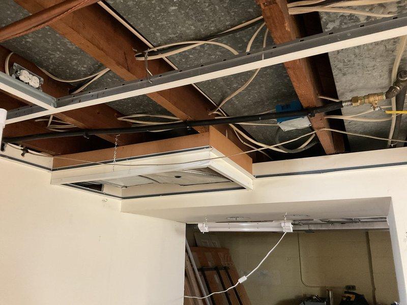 Responded to a laundry room service call to address dryer venting concerns. Upon inspection, identified improper dryer vent configuration with flexible aluminum ducting and inadequate routing from the appliance to the exterior termination point. Accessed the ceiling cavity above the laundry area to assess the existing vent pathway and structural limitations. Documented the current installation showing the LG front-loading washing machine placement, existing wall-mounted vent components, and the flexible white ribbed ducting material. Photographed the overhead framing, joists, and existing utility lines to plan proper vent routing that complies with code requirements for rigid or semi-rigid metallic ductwork with minimal bends and appropriate clearances from electrical wiring and insulation. Provided recommendations for correcting the ventilation system to ensure proper airflow, reduce lint accumulation risk, and improve dryer efficiency and safety.