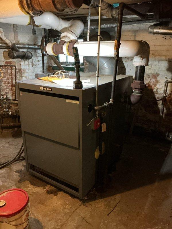 Responded to no heat call on 5-year-old Weil-McLain steam boiler located in basement mechanical room. Diagnosed failed spark ignition box and pilot assembly preventing unit from firing. Removed defective ignition components and installed new spark ignition box and pilot assembly at shop under purchase order, restoring proper ignition sequence and heat operation to building.
