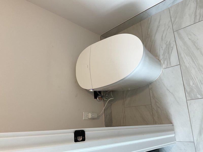 Completed professional toilet installation in residential bathroom with marble-effect tile finishes. Removed existing fixture, installed new contemporary white toilet with proper mounting hardware and plumbing connections, ensured proper sealing and functionality. All work performed to code standards with fixtures tested and confirmed operational upon completion.
