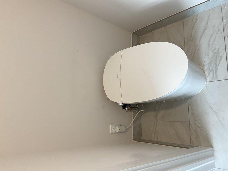 Completed professional toilet installation in residential bathroom with marble-effect tile finishes. Removed existing fixture, installed new contemporary white toilet with proper mounting hardware and plumbing connections, ensured proper sealing and functionality. All work performed to code standards with fixtures tested and confirmed operational upon completion.