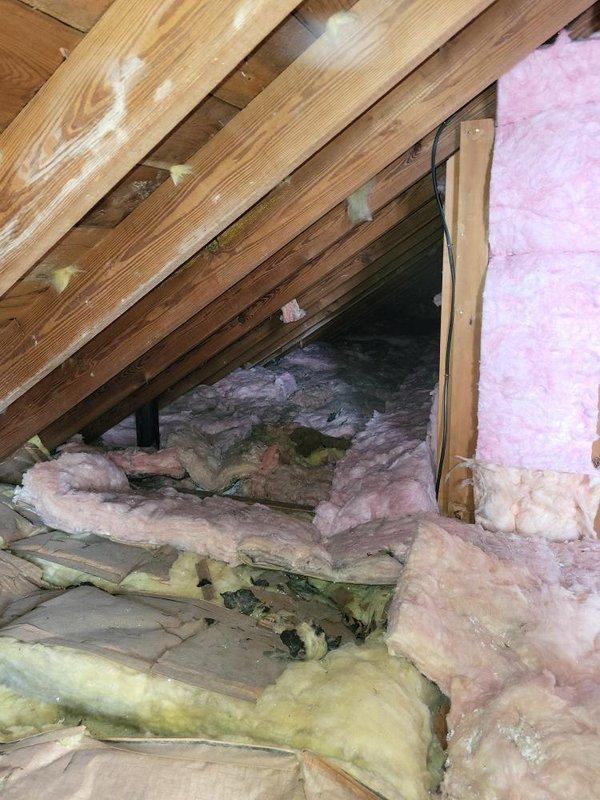 Conducted comprehensive site assessment for high velocity air conditioning system installation. Evaluated attic space for equipment placement and ductwork routing, noting existing insulation conditions with pink and yellow fiberglass materials present throughout space. Documented structural elements including exposed wooden rafters, joists, and framing to determine optimal system configuration. Photographed attic access points, available clearances, and existing electrical wiring for system planning purposes. Assessment completed to provide accurate estimate for full high velocity AC system installation.