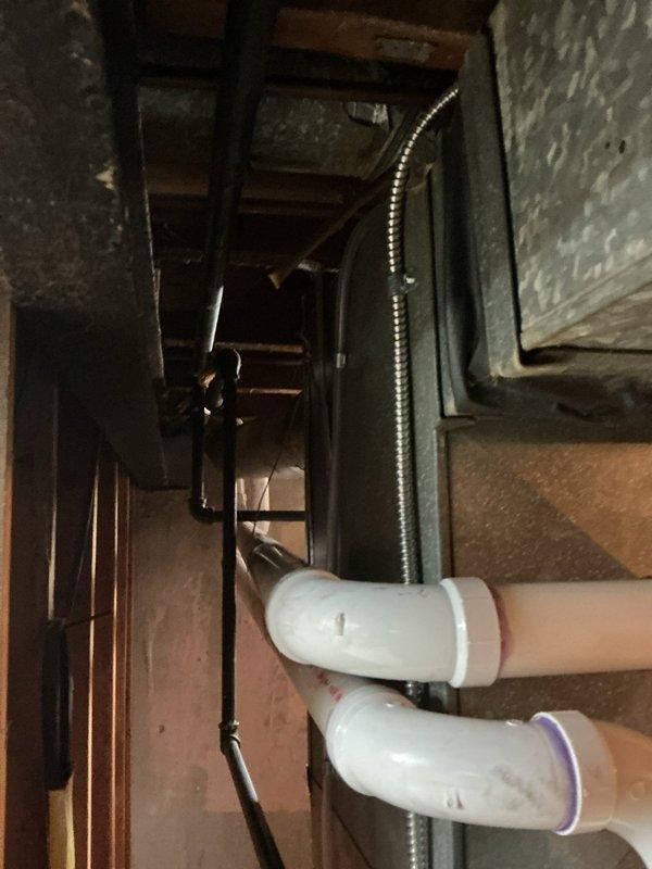Responded to service call regarding damaged gas line to dryer allegedly caused by previous installation work. Upon inspection of mechanical room and utility space, documented existing gas piping configuration, water heater installation, HVAC equipment placement, and associated utility connections. Photographed current conditions showing vertical gas piping runs, PVC plumbing lines, and flexible ductwork in confined utility area to establish baseline assessment of reported issue.