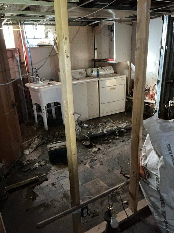 Responded to gas leak in basement previously identified by utility company. Upon arrival, found home under active renovation with exposed framing, debris, and construction materials throughout basement area. Performed thorough inspection of existing gas piping system of unknown age to locate source of leak. Evaluated all gas line connections, joints, and fittings in basement area where leak was reported. System remained operational during inspection. Documented conditions with photographs showing basement renovation status and exterior mechanical equipment including pump assembly mounted on foundation wall. Provided assessment of gas piping condition and leak location for necessary repairs to ensure safe operation of gas system.