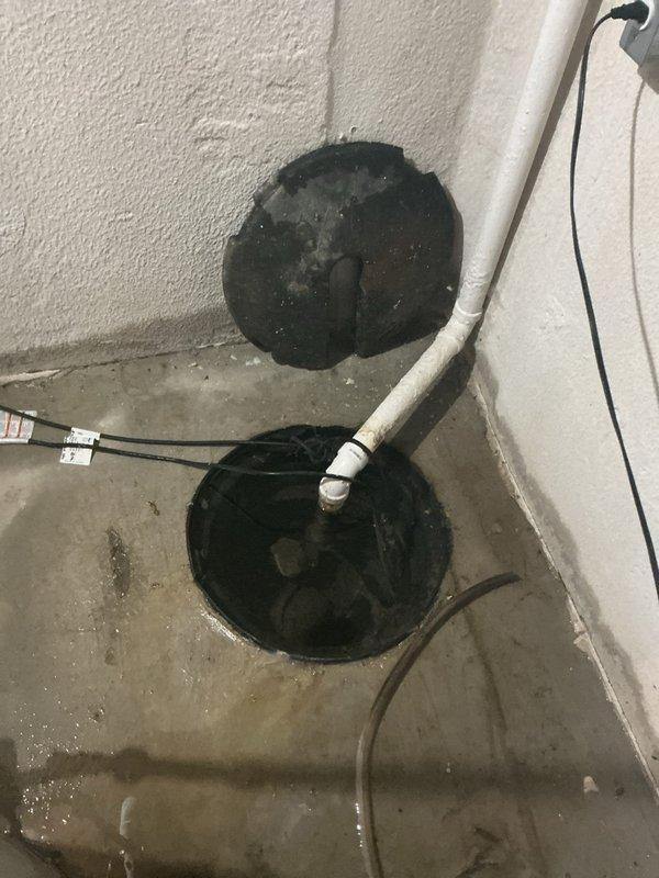 Responded to a service call for a non-functioning sump pump system in the basement. Upon arrival, assessed the existing sump pump installation located in a corner basin with vertical PVC discharge piping. The pump had failed and required replacement. Removed the old pump unit from the basin and installed a new submersible sump pump with appropriate float switch mechanism. Verified proper electrical connections and secured the power cord along the wall. Tested the new pump operation to ensure adequate water discharge through the existing PVC pipe system and confirmed the basin was draining effectively. System restored to full working condition.