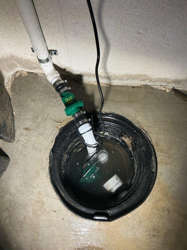 Responded to a service call for a non-functioning sump pump system in the basement. Upon arrival, assessed the existing sump pump installation located in a corner basin with vertical PVC discharge piping. The pump had failed and required replacement. Removed the old pump unit from the basin and installed a new submersible sump pump with appropriate float switch mechanism. Verified proper electrical connections and secured the power cord along the wall. Tested the new pump operation to ensure adequate water discharge through the existing PVC pipe system and confirmed the basin was draining effectively. System restored to full working condition.