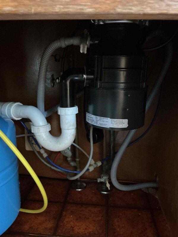 Responded to service call for non-functional garbage disposal and slow-draining bathroom sink. Inspected three-quarter horsepower InSinkErator unit that had been inoperative for several months. Evaluated electrical connections, reset mechanism, and internal components of disposal unit. Assessed drainage system and P-trap configuration beneath kitchen sink. Addressed bathroom vanity sink experiencing recent drainage issues by clearing obstruction and testing water flow to restore proper drainage function. Verified all plumbing connections, flexible hoses, and PVC pipe assemblies were secure and functioning correctly upon completion.