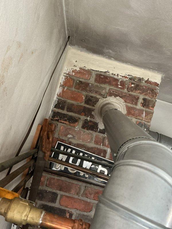 Returned to address plumbing inspection violation on water heater installation where the vent pipe had been improperly reduced from 4-inch to 3-inch diameter. Corrected the venting configuration to maintain proper 4-inch diameter throughout the vent run as required by code, ensuring adequate draft and combustion gas exhaust. Documented the completed correction with photographs for inspector approval as requested.