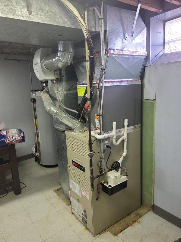 Responded to service call for furnace not turning on in basement location. Upon inspection, found 2002 model furnace over 10 years old showing signs of failure. Evaluated existing HVAC system including electrical panel connections, ductwork configuration, and auxiliary components including humidifier. Documented current installation with metallic flexible ductwork, PVC condensate drain lines, and existing circuit breaker setup. Prepared comprehensive replacement estimate for new furnace system to restore heating functionality to residence.