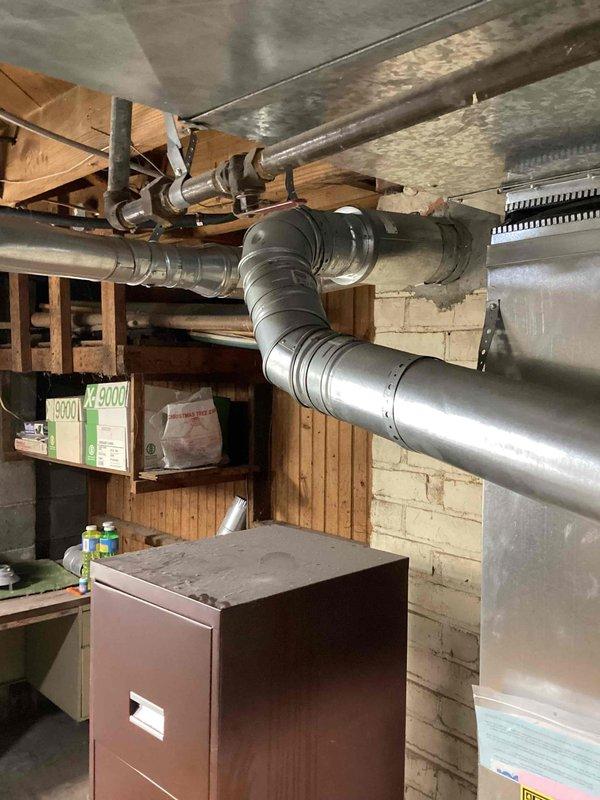 Completed on-site assessment for furnace and air conditioner replacement estimate on 23-year-old HVAC system. Inspected existing equipment including furnace unit in basement utility area with associated ductwork and external AC condenser unit. Documented current system configuration, ductwork routing through basement joists, and exterior condenser location to provide comprehensive replacement options for both heating and cooling units that have reached end of serviceable life.