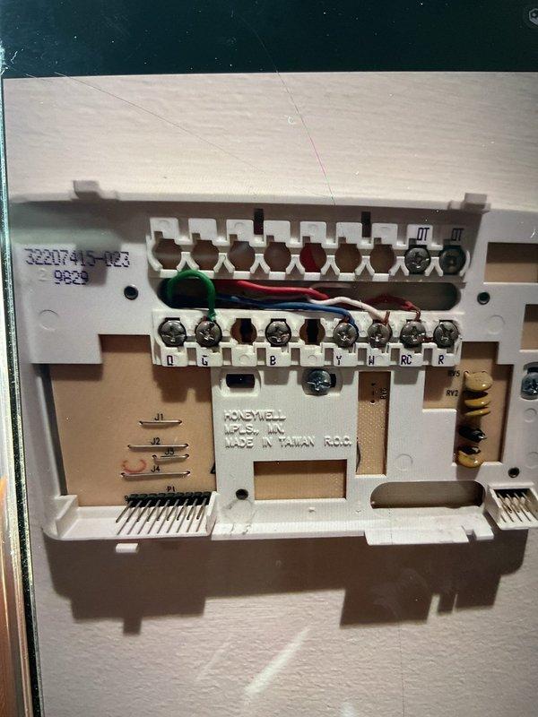 Responded to service call for bedroom thermostat continuously running furnace and causing overheating condition on 6-year-old unit. Inspected Honeywell thermostat wiring and terminal connections, verified proper wire placement at R, RC, W, Y, G, and B terminals. Examined furnace control board, confirmed LED status indicator functioning and all low-voltage wiring connections secure at terminal blocks. Identified thermostat malfunction causing continuous call for heat, preventing furnace from cycling properly. Corrected wiring configuration and tested system operation to ensure proper heating cycles and temperature control restored.