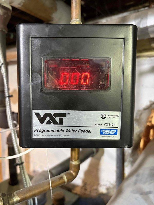 Responded to no heat call for 10-year-old boiler system located in basement. Upon inspection, identified malfunctioning VXT-24 Programmable Water Feeder control unit displaying error code. Tested system pressure and water feed functionality, confirmed low water condition preventing boiler operation. Replaced defective water feeder control, recalibrated system settings, purged air from lines, and restored proper water level. Verified boiler ignition sequence, confirmed heat delivery to zones, and tested safety controls for proper operation. System restored to full functionality with heat confirmed throughout property.
