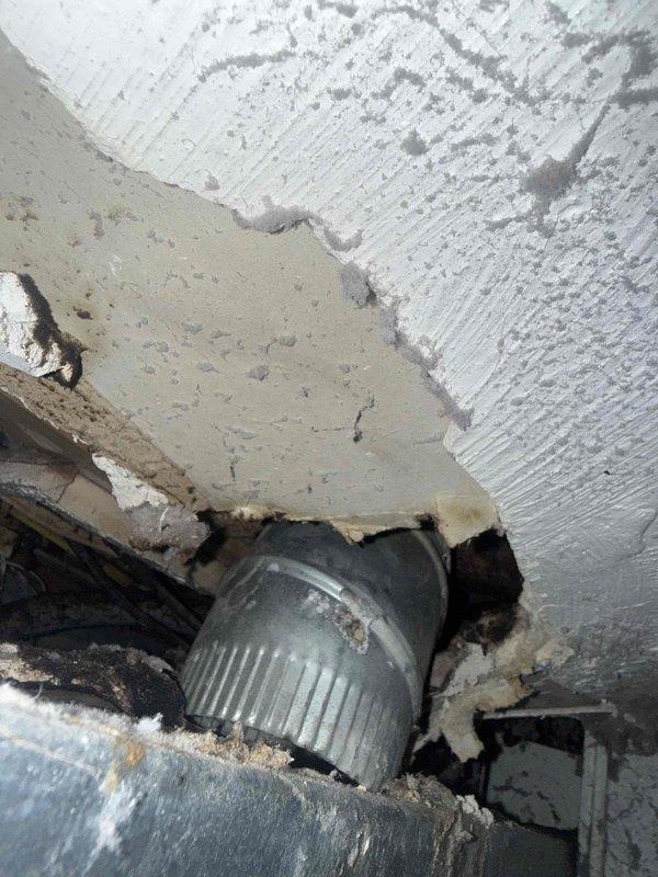 Performed diagnostic inspection of dryer vent system and evaluated drywall damage around vent penetration. Found deteriorated seal and rough opening where cylindrical duct passes through wall/ceiling junction, with exposed drywall edges and gaps compromising air barrier integrity. Documented conditions of metallic ductwork, electrical panel, and glass block windows in mechanical space for repair recommendations.