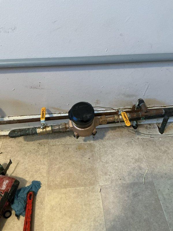 Completed water meter repair and replacement service. Removed aged meter assembly showing significant corrosion and discoloration on brass fittings and copper piping. Installed new meter with proper connections, ensuring all fittings were secured and system was tested for leaks before completion.