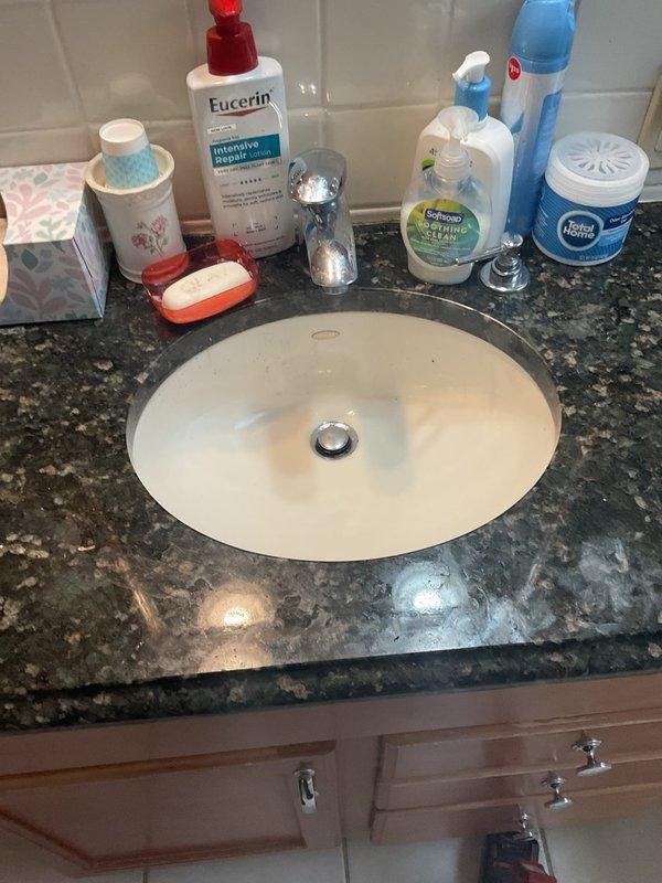 Completed plumbing service call for bathroom fixture maintenance. Inspected undermount sink installation with chrome drain assembly beneath granite vanity countertop, verified proper drainage function and seal integrity. All fixtures operating within normal parameters upon completion of service visit.