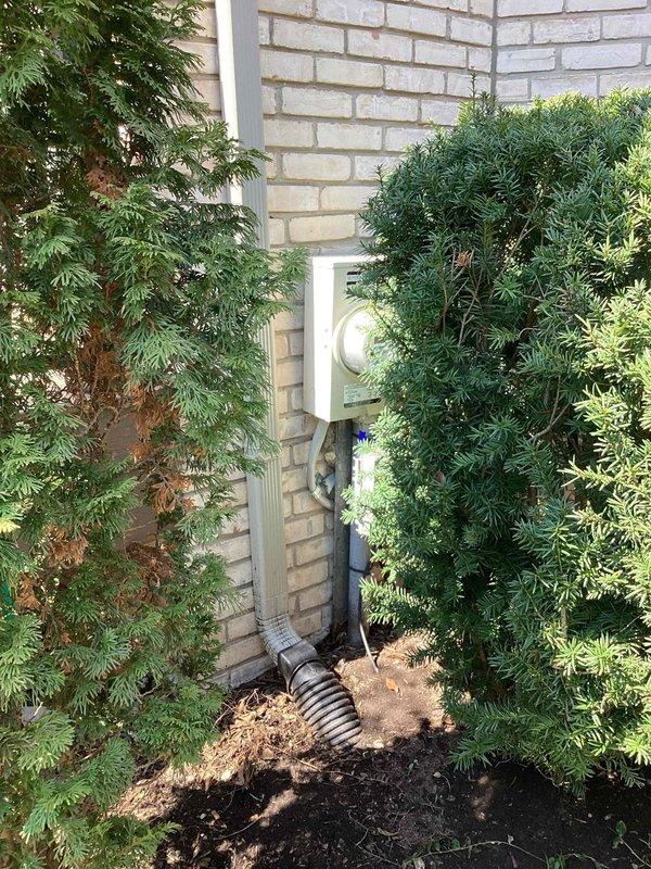 Performed comprehensive diagnostic evaluation on 20-year-old Bryant air conditioning system located in backyard. Identified low refrigerant charge and weak capacitor during routine tune-up inspection. System currently operational but exhibiting performance deficiencies due to age and component degradation. Documented equipment condition with photographic evidence showing outdoor condenser unit positioned against brick exterior wall with electrical disconnect properly installed. Provided replacement estimate due to advanced age of equipment and identified deficiencies requiring attention for continued reliable operation.