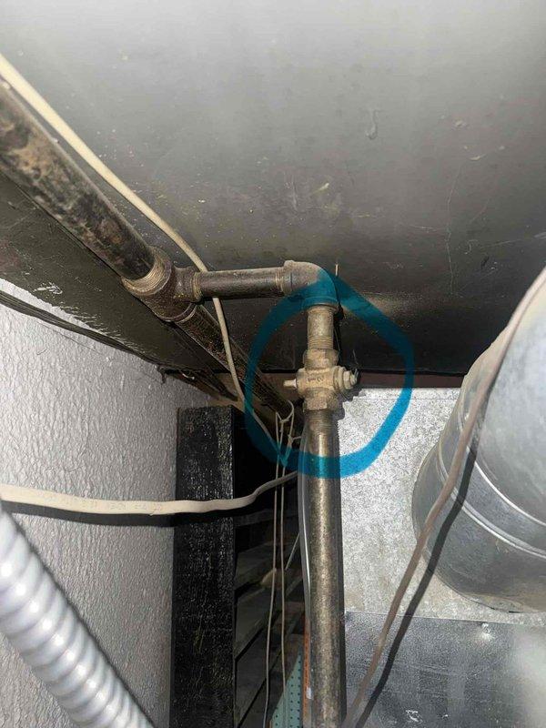 Responded to emergency service call for 20-year-old furnace with multiple leak points in basement installation. Upon arrival, found gas service already locked and tagged off by utility company due to hazardous conditions identified during their inspection. Documented existing Consumers Energy hazardous condition notice indicating dangerous operating conditions requiring immediate attention before gas restoration. Conducted thorough visual inspection of furnace cabinet, heat exchanger, flue connections, and associated plumbing components. Photographed locked gas valve assembly with blue flexible connector and surrounding mechanical systems showing age-related deterioration and dust accumulation. Assessed compromised furnace integrity and determined unit had reached end of serviceable life with multiple failure points presenting safety concerns. Given the utility company lockout, age of equipment, and extent of deterioration observed, recommended full furnace replacement as the appropria