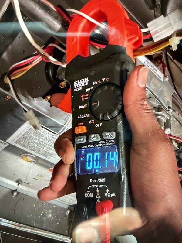 Responded to a no-heat call where the gas furnace in the basement was running but blowing room temperature air only. Upon inspection with the access panel removed, performed electrical diagnostics using a clamp meter which revealed a 0.14 amp draw, indicating the induced draft blower motor was operating but the burners were not igniting. Troubleshot the ignition sequence and gas valve assembly, checking pressure switches, flame sensor, and control board connections to identify the failure point preventing proper burner operation and heat production.
