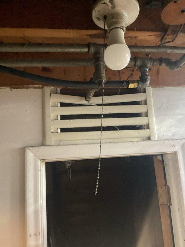 Provided estimate for installation of new half-inch TRAC gas line to supply kitchen stove. Assessed existing basement utility area infrastructure, including current gas piping configuration, ceiling-mounted fixtures, and available routing paths through exposed joists. Documentation photos captured existing conditions of utility space, including ceiling structure, exposed piping, and access points for proposed gas line installation.