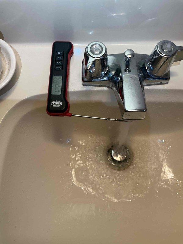 Completed comprehensive inspection of basement-located furnace and air conditioning system, including thorough evaluation of humidifier, thermostat, and hot water tank components. Performed temperature diagnostics at plumbing fixtures using digital thermometer to verify hot water tank performance and proper water temperature delivery throughout the system. All equipment inspected and tested for proper operation, with measurements documented photographically for service records.