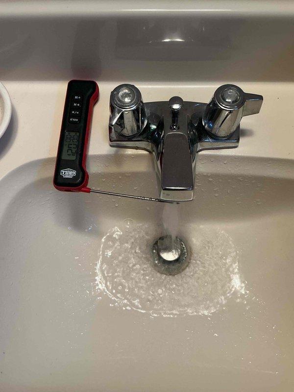 Completed comprehensive inspection of basement-located furnace and air conditioning system, including thorough evaluation of humidifier, thermostat, and hot water tank components. Performed temperature diagnostics at plumbing fixtures using digital thermometer to verify hot water tank performance and proper water temperature delivery throughout the system. All equipment inspected and tested for proper operation, with measurements documented photographically for service records.