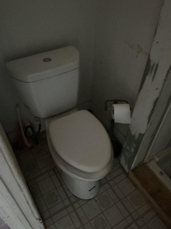 Responded to multiple toilet flushing issues across two units in a four-family residential building. Inspected and diagnosed flush mechanisms in several toilets, identifying worn internal components including deteriorated flapper valves and fill valve assemblies with significant mineral buildup and sediment accumulation in tank interiors. Installed one new toilet unit in designated apartment to replace non-functional fixture. Investigated reported water leak concern between upper and lower unit bathrooms, examining ceiling areas, supply lines, wax ring seals, and tank-to-bowl connections to determine source of moisture intrusion. Performed necessary adjustments to flush valve assemblies and water supply mechanisms to restore proper flushing operation across affected fixtures. Documented conditions with photographic evidence showing existing hardware deterioration and mineral deposits consistent with aged plumbing system in 111-year-old structure.