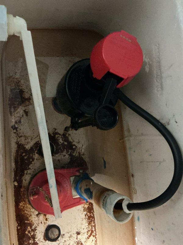 Responded to multiple toilet flushing issues across two units in a four-family residential building. Inspected and diagnosed flush mechanisms in several toilets, identifying worn internal components including deteriorated flapper valves and fill valve assemblies with significant mineral buildup and sediment accumulation in tank interiors. Installed one new toilet unit in designated apartment to replace non-functional fixture. Investigated reported water leak concern between upper and lower unit bathrooms, examining ceiling areas, supply lines, wax ring seals, and tank-to-bowl connections to determine source of moisture intrusion. Performed necessary adjustments to flush valve assemblies and water supply mechanisms to restore proper flushing operation across affected fixtures. Documented conditions with photographic evidence showing existing hardware deterioration and mineral deposits consistent with aged plumbing system in 111-year-old structure.
