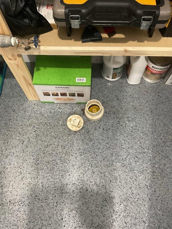 Responded to basement drainage emergency where rainwater was backing up through floor drain and pooling on surface. Upon inspection, located affected floor drain in basement workout area with visible water staining and standing water on terrazzo flooring. Assessed drainage system for blockage, performed diagnostic evaluation of main line connection, and cleared obstruction preventing proper water flow. Verified drain functionality and confirmed water now flowing freely through system without backup.