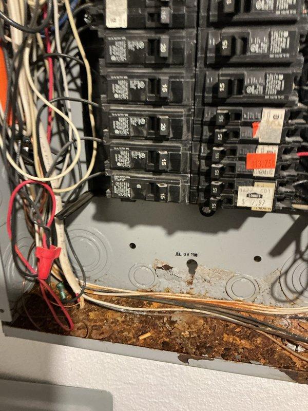 Responded to service call for electrical panel experiencing water intrusion and corrosion in basement area. Upon inspection, found extensive rust and deterioration on lower portion of panel enclosure due to moisture exposure during rain events. Panel base showed significant corrosion, pitting, and accumulated debris with rust staining across metal surfaces. Circuit breakers in upper section remained functional but panel integrity was compromised by water damage at bottom where conduits enter. Documented existing conditions with photographs showing corroded panel base, deteriorated metal components, and moisture-related damage to enclosure while breakers remained operational above affected area.