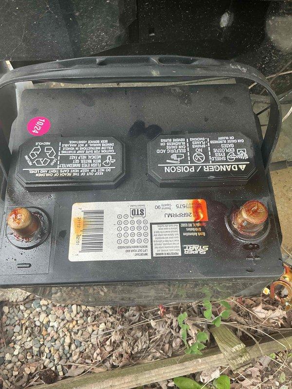 Performed generator maintenance inspection per Gold plan service agreement. Inspected 12-volt battery and identified moderate corrosion buildup on both positive and negative terminal posts. Battery is approximately three years old and displays date indicator of 12/14. Visual inspection of Daikin outdoor condenser unit completed, with equipment showing normal operational condition and typical weathering for exterior installation. Air handler located in basement per system configuration.