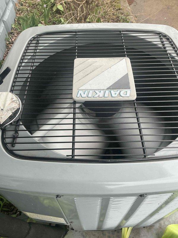 Performed generator maintenance inspection per Gold plan service agreement. Inspected 12-volt battery and identified moderate corrosion buildup on both positive and negative terminal posts. Battery is approximately three years old and displays date indicator of 12/14. Visual inspection of Daikin outdoor condenser unit completed, with equipment showing normal operational condition and typical weathering for exterior installation. Air handler located in basement per system configuration.