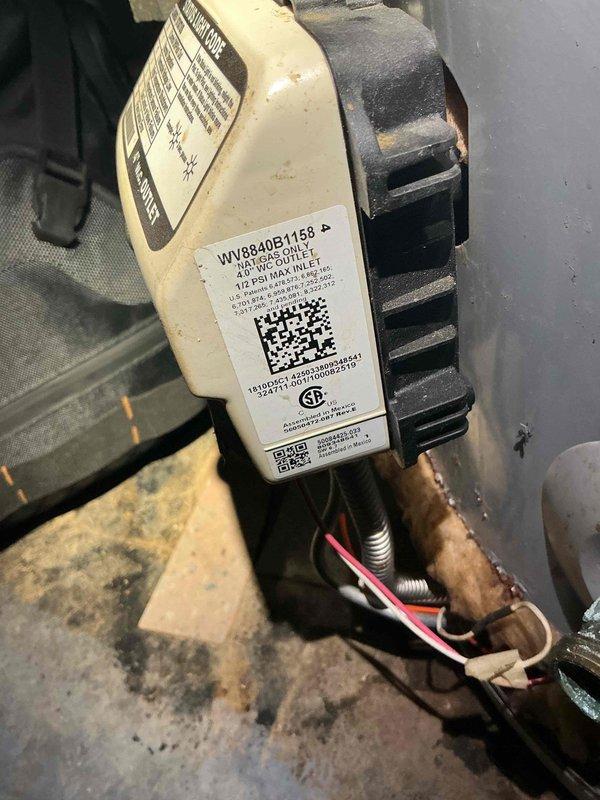 Responded to a no hot water complaint affecting the property for two weeks. Upon inspection, discovered a failed gas valve assembly with significant corrosion on electrical connections and mounting hardware. The gas valve showed evidence of moisture exposure leading to terminal degradation. Verified furnace ignition system was operational with visible flame present in combustion chamber. Documented corroded wiring and compromised valve components for replacement recommendation.