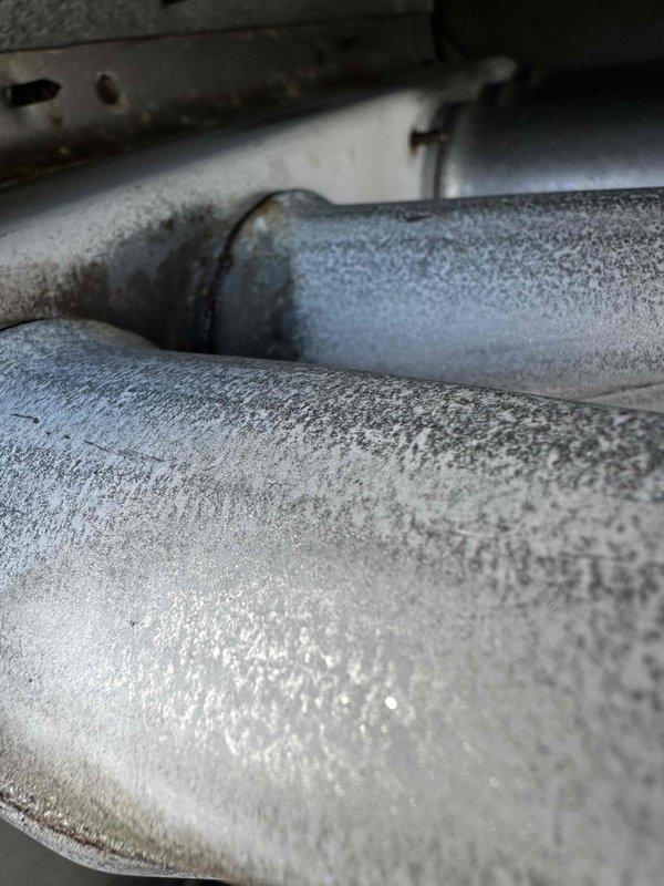 Responded to no heat call for office area rooftop unit on 10+ year old equipment. Upon inspection, discovered heavy frost and ice accumulation on refrigerant lines and evaporator coil, indicating restricted airflow or low refrigerant charge causing the coil to freeze. Found evaporator coil with significant moisture buildup, rust-colored staining, and corrosion, suggesting prolonged exposure to condensation and potential drainage issues. System was unable to provide adequate heating to office space due to frozen coil condition blocking airflow through the unit.