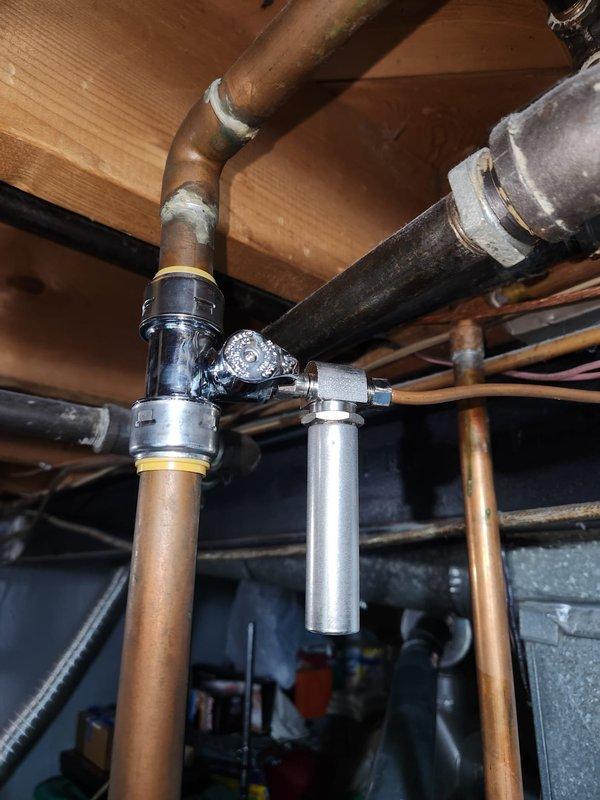 Installed water hammer arrestor on humidifier line to correct plumbing code violation. Arrestor was mounted at pipe junction near existing pressure regulator using compression fittings on copper supply lines. All connections were properly secured and tested for leaks to ensure compliant installation.