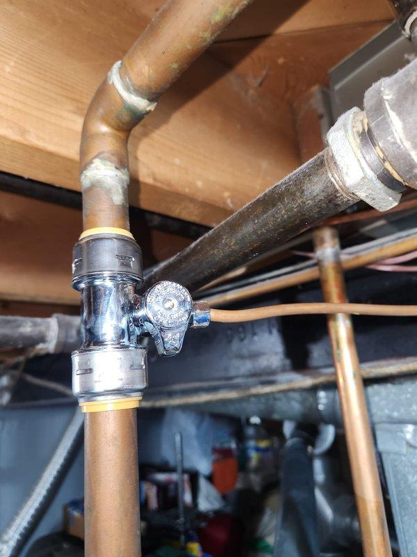 Installed water hammer arrestor on humidifier line to correct plumbing code violation. Arrestor was mounted at pipe junction near existing pressure regulator using compression fittings on copper supply lines. All connections were properly secured and tested for leaks to ensure compliant installation.